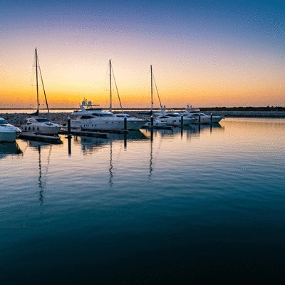 Scenic view of luxury yachts docked at the Glenelg Marina Pier at sunset
